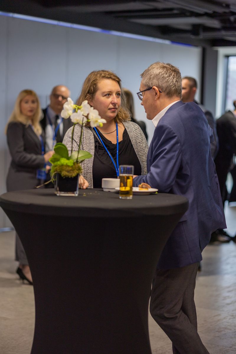 rozmowa dwójki uczestników konferencji przy stoliku koktajlowym