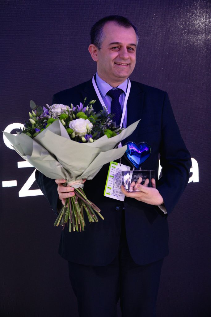 Tomasz Zieliński trzymający kwiaty i nagrodę