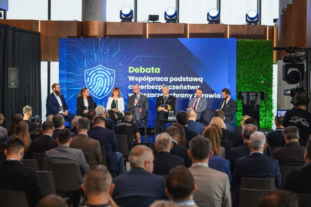 widok na scene gdzie siedzą uczestnicy debaty