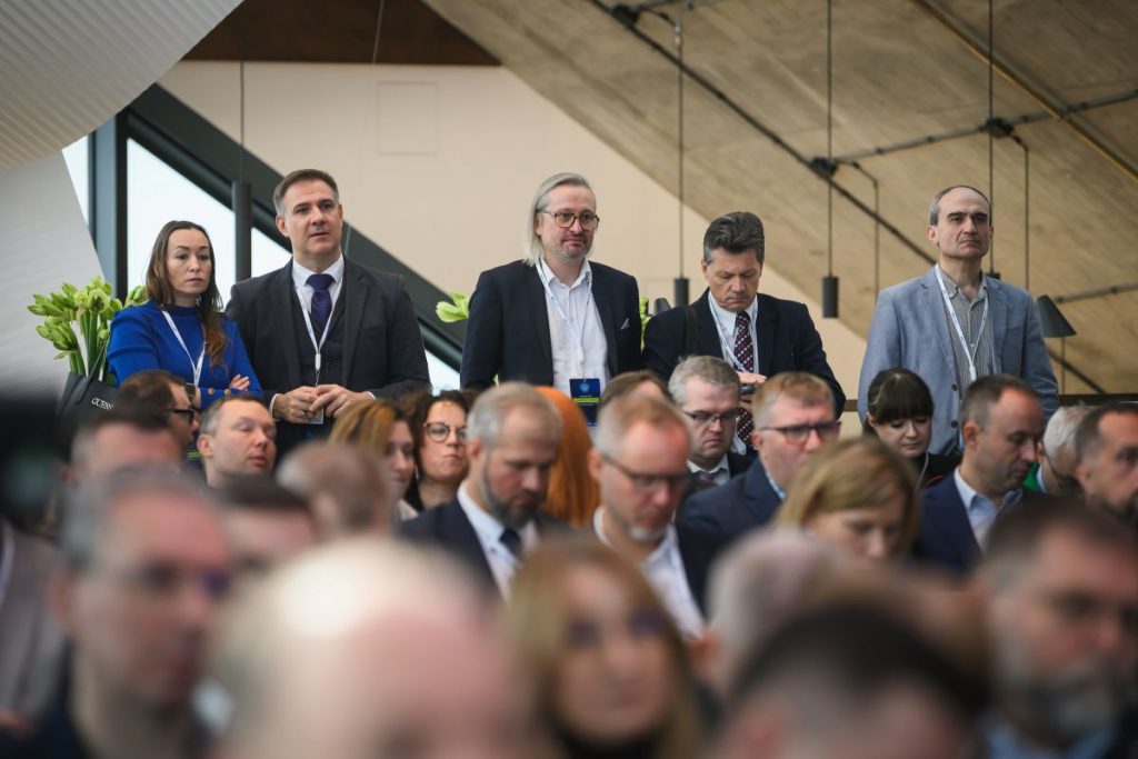 widok na uczestników konferencji stojących na końcu sali