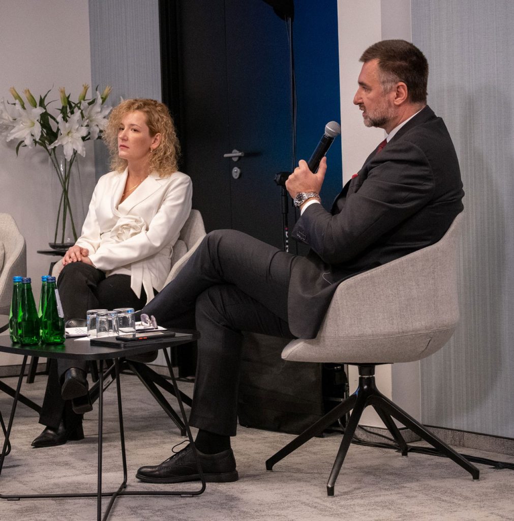 Adam Konka jako moderator w panelu drugim trzymający mikrofon, obok siedząca Karolina Tędel